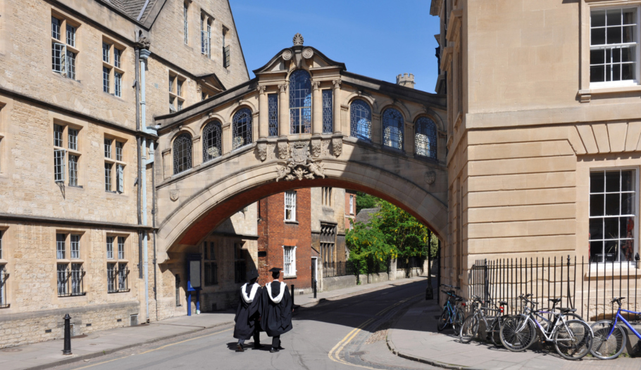 Oxford university graduates walking between two buildings